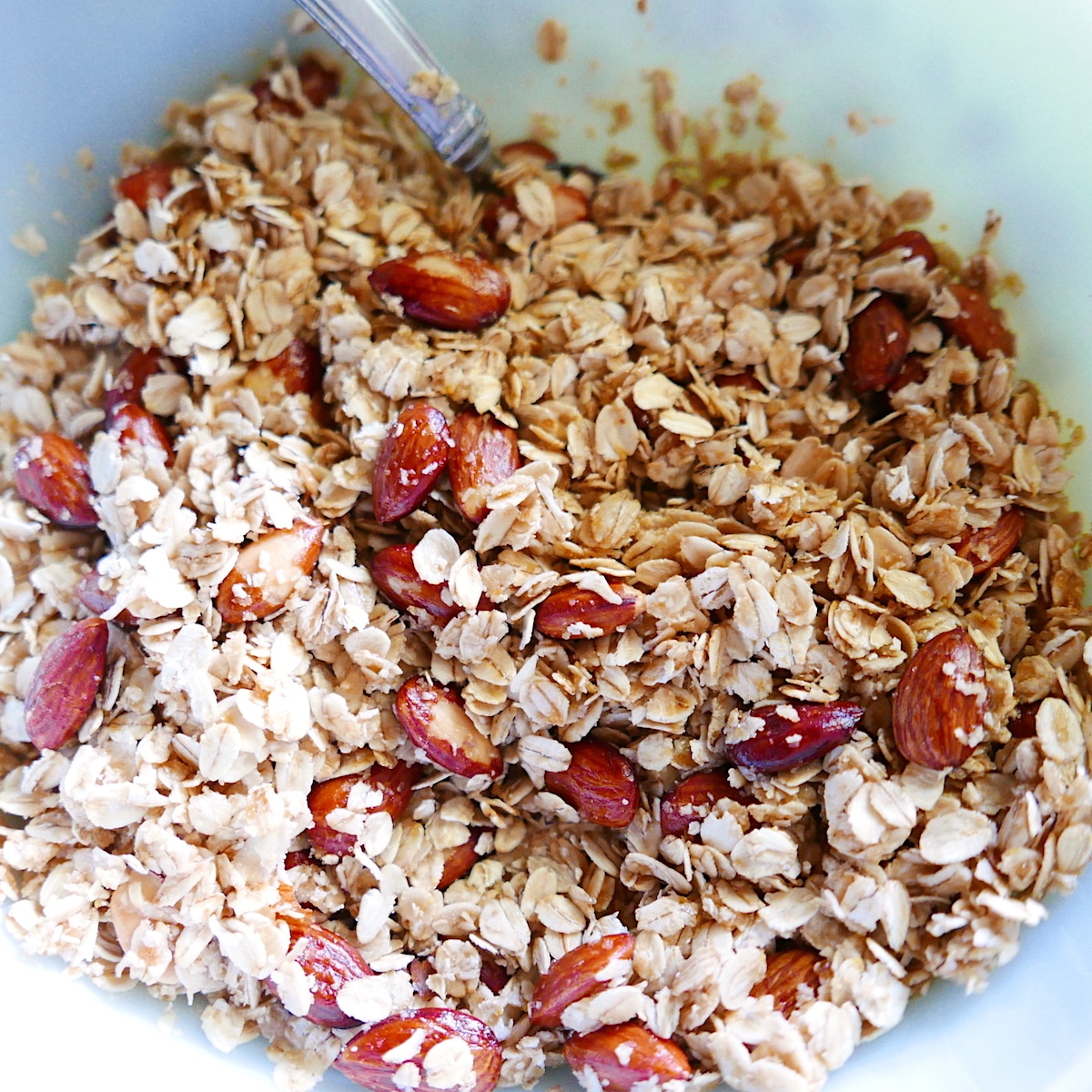 Mixing the oats, nuts, coconut, and brown sugar in a large bowl.