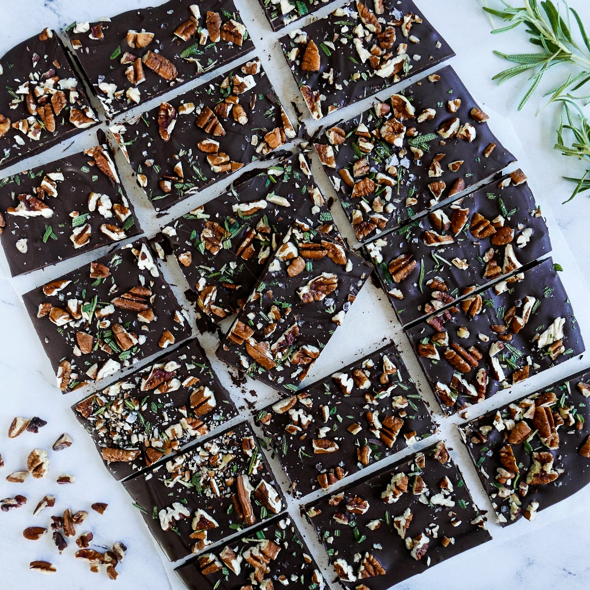 pecan-bark-cut-into-squares.jpg chocolate pecan bark cut into squares and arranged on marble table.