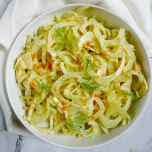 citrus fennel salad with fronds in a white bowl with white napkin