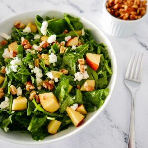 apple walnut goat cheese salad in white bowl