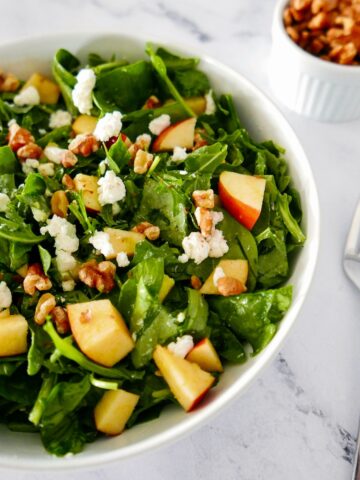 apple walnut goat cheese salad in a white bowl