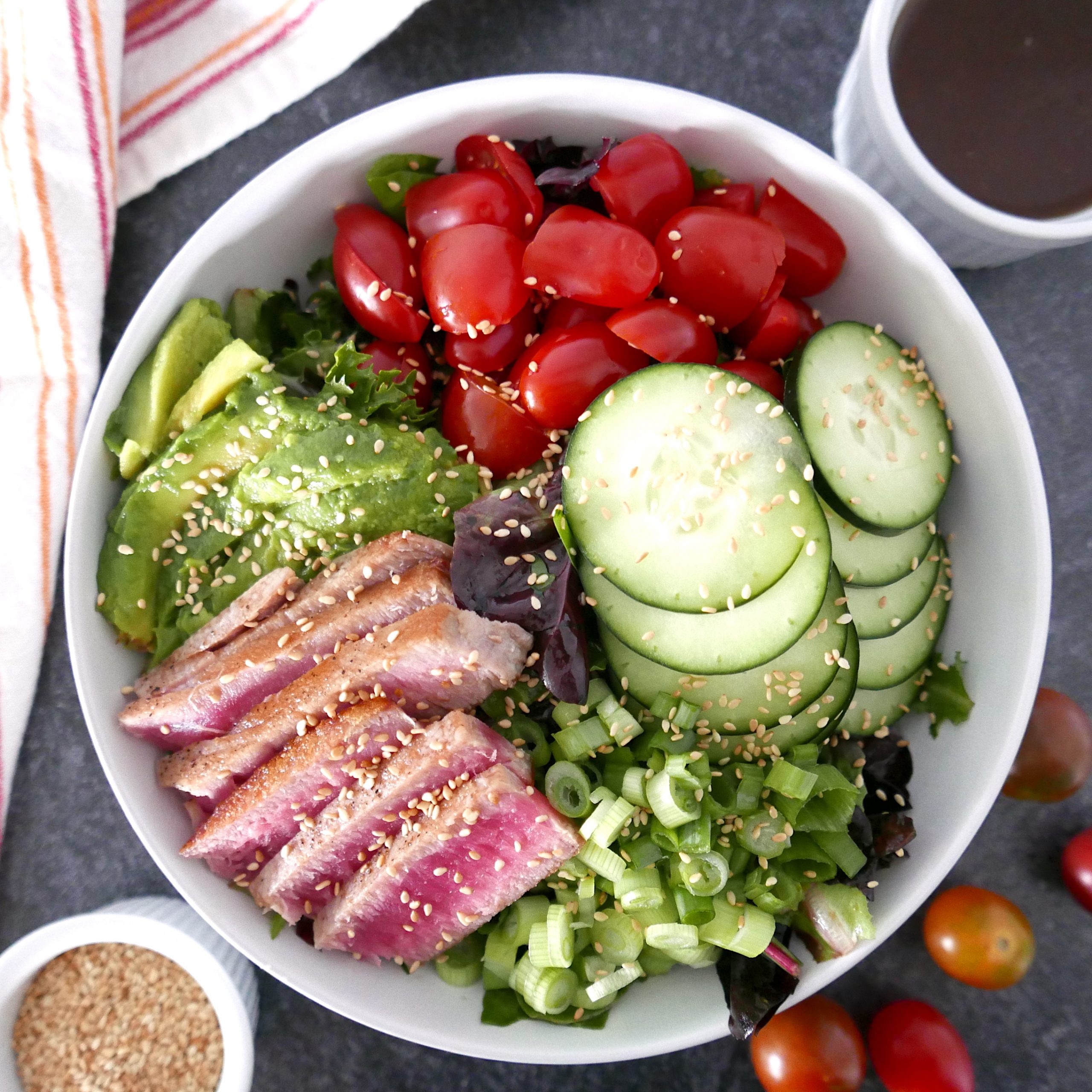 tuna steak salad with wasabi vinaigrette in a large white bowl sitting on a marble counter top