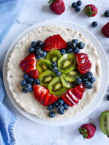 vegan fruit tart with kiwi and berries on a platter