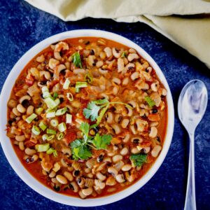 ethiopian black eyed peas with coconut milk in a white bowl with spoon