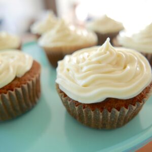 carrot cake cupcakes displayed on a teal cake stand