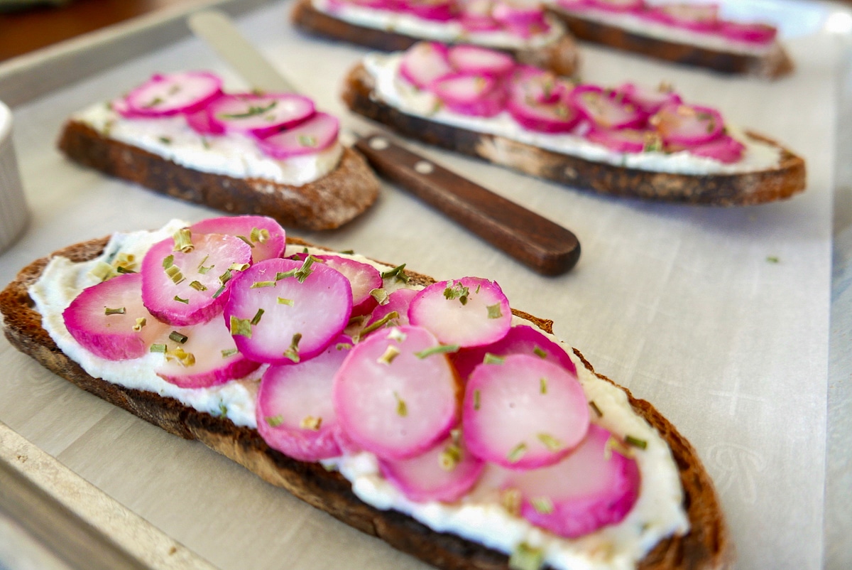 roasted-radish-and-herbed-ricotta-toasts.jpg roasted radish and herbed ricotta toasts on a baking sheet.