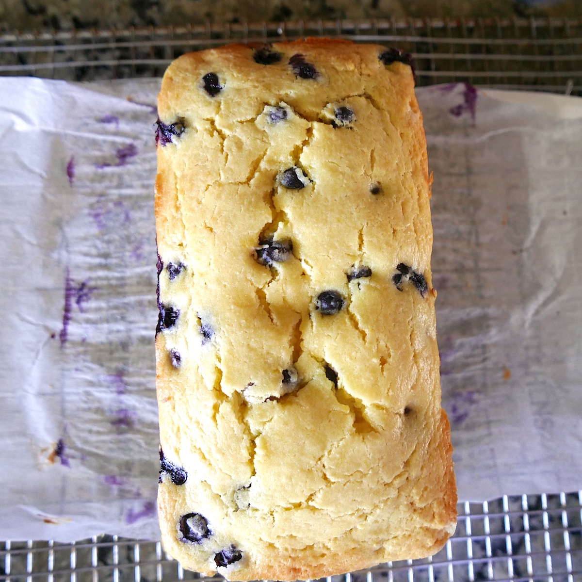Loaf of pound cake resting on a cooling rack.