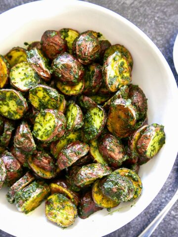 roasted red skin potatoes with cilantro chimichurri in a white bowl