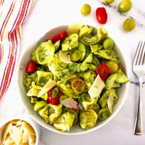 bowl of summer tortellini salad with tomatoes and a fork.