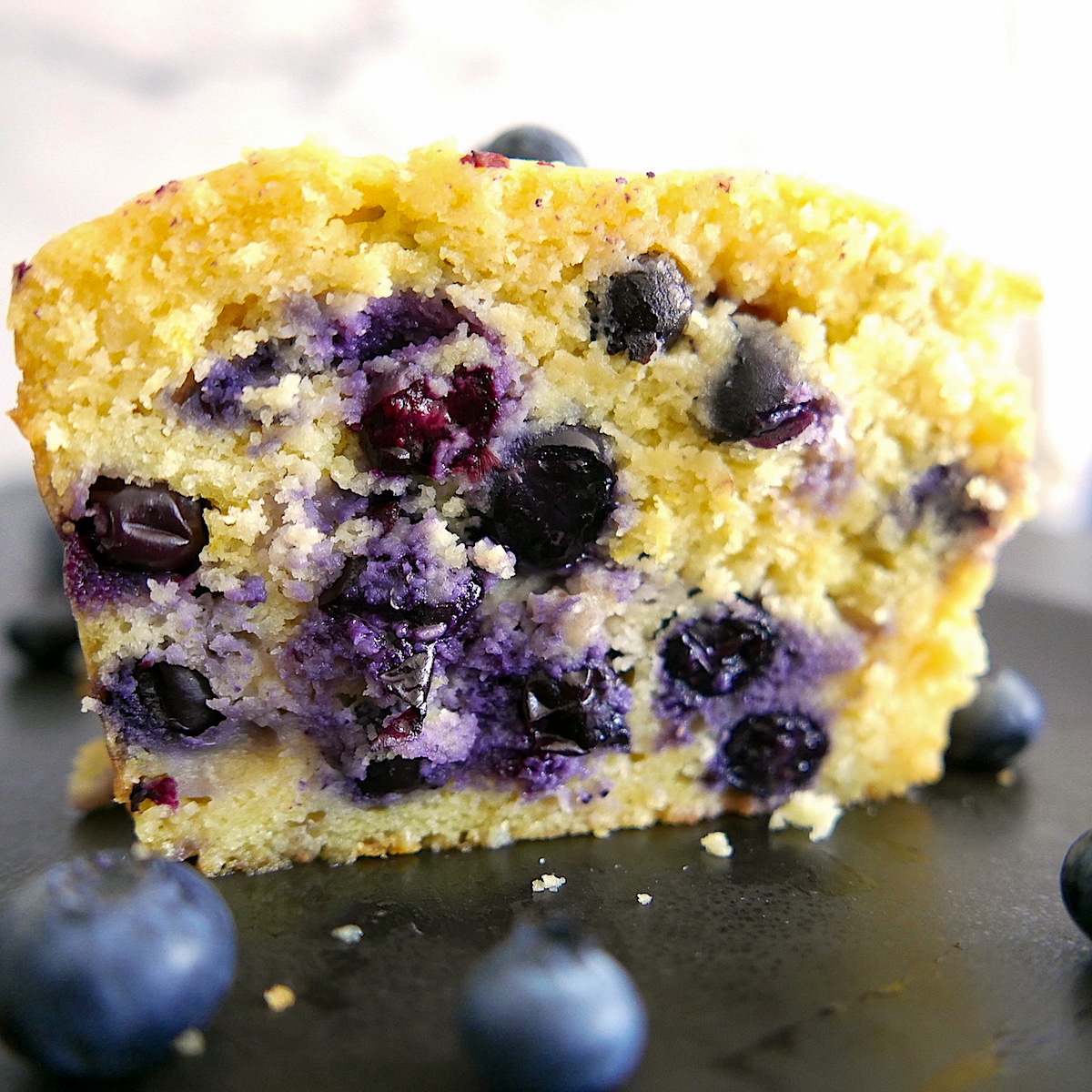 blueberry lemon ricotta pound cake cut open on a platter.