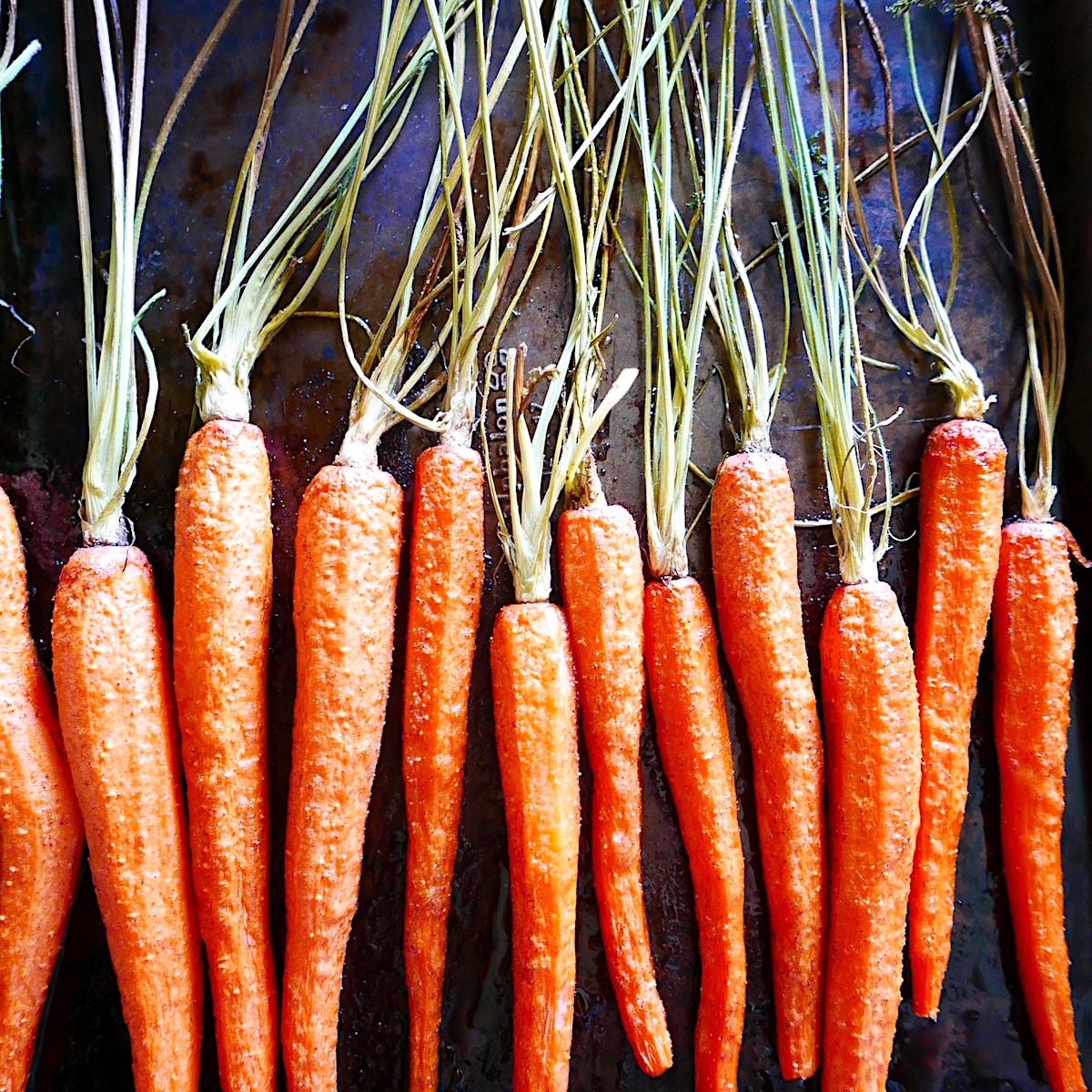 roasted carrots arranged on a baking sheet.