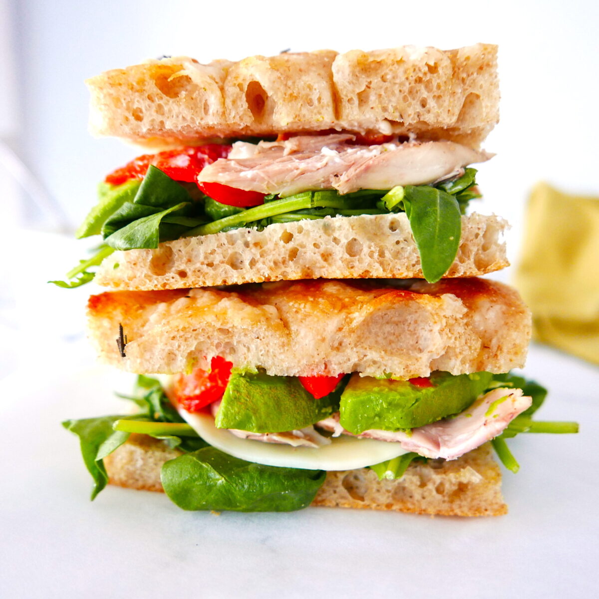 Two sandwiches with rotisserie chicken stacked on top of each other.