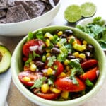 black bean corn avocado salsa in a bowl garnished with cilantro.