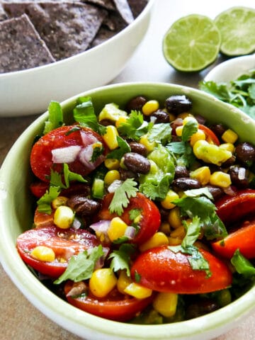 black bean corn avocado salsa in a bowl garnished with cilantro.