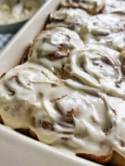 pan of cinnamon rolls with cup of coffee on the side.