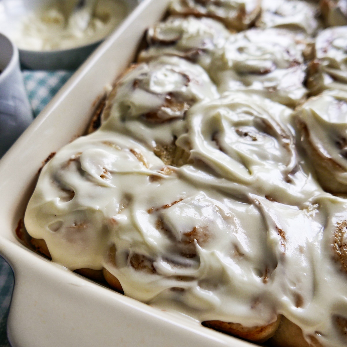 pan of cinnamon rolls with cup of coffee on the side.