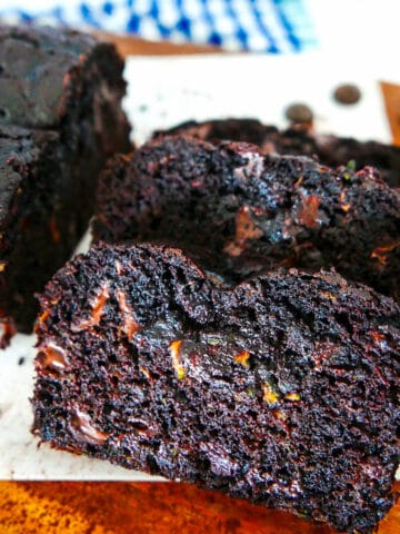 death by chocolate zucchini bread sliced on a wooden cutting board.