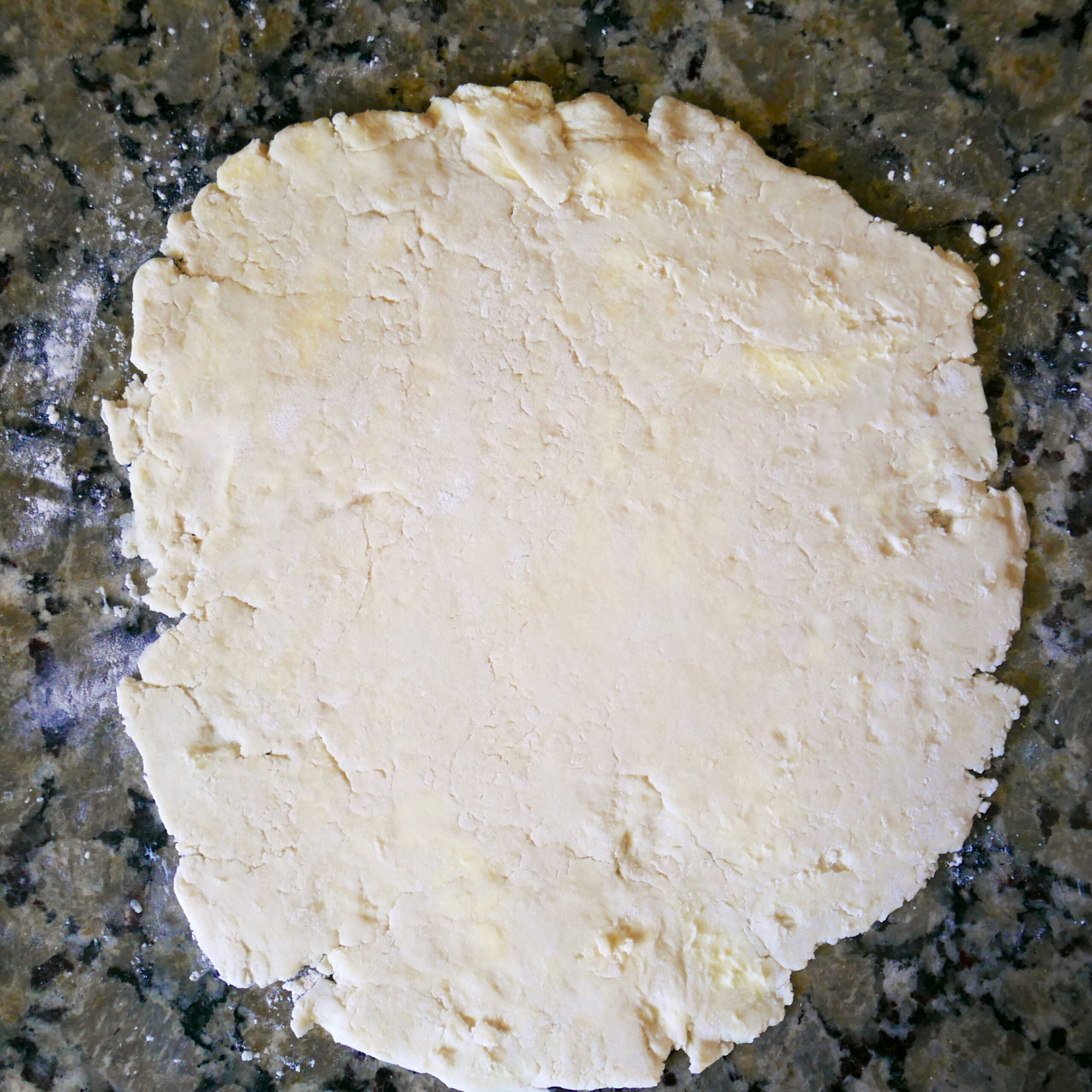galette dough being rolled out on a counter top.