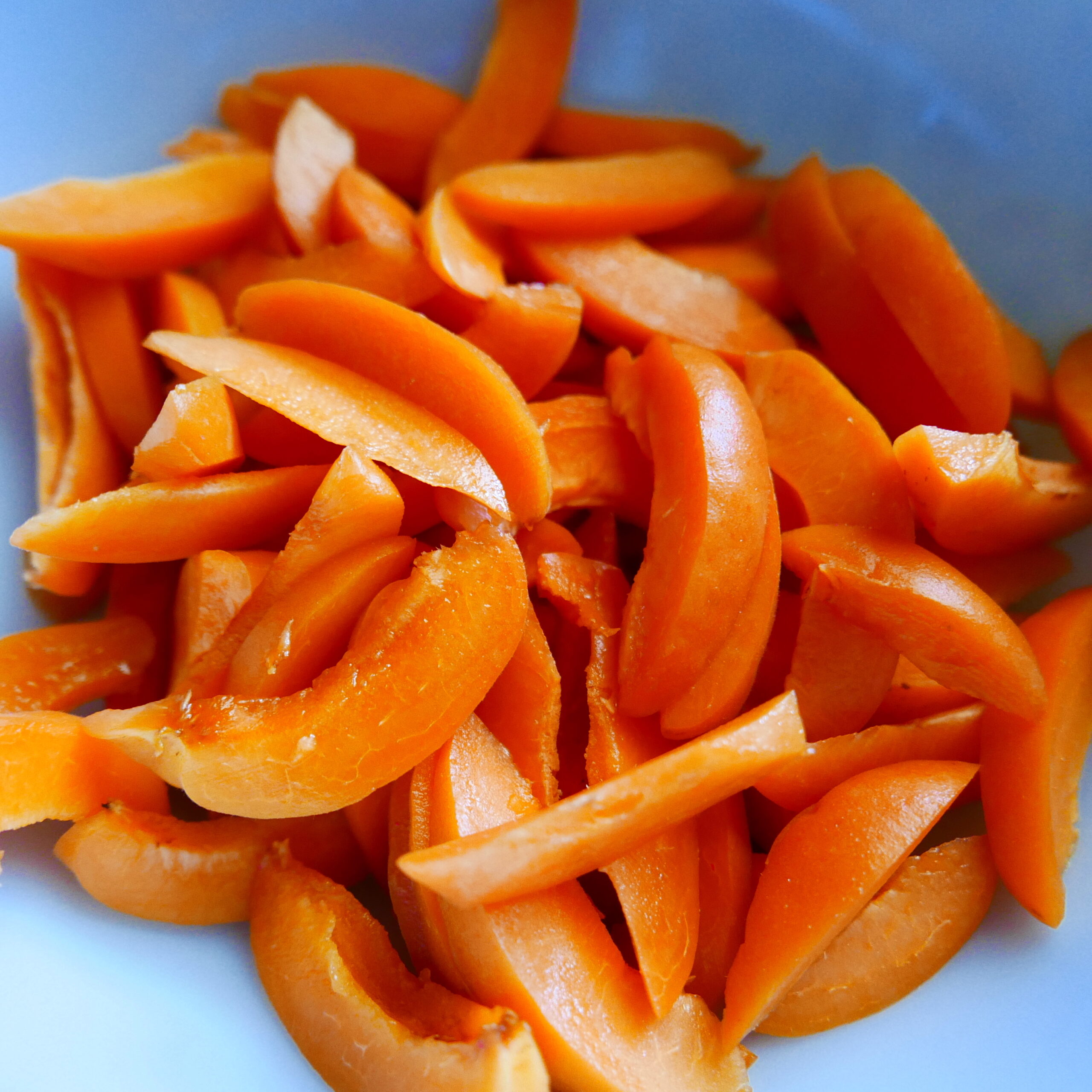 sliced apricots being tossed with sugar and lemon juice in a bowl.
