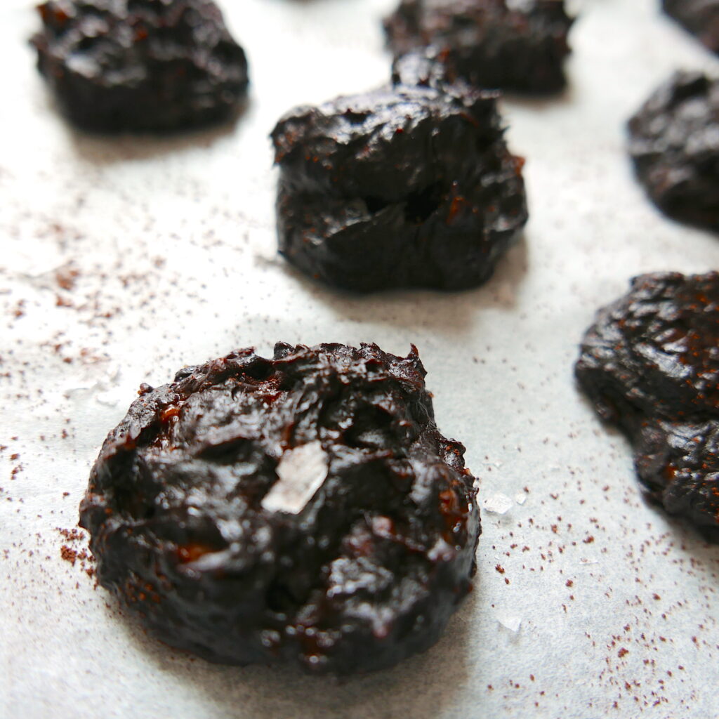 close up of peanut butter fudge cookie on a baking sheet with more cookies in the background