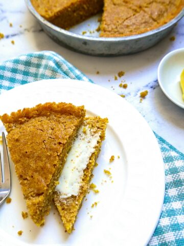 sourdough cornbread on white plate with pan in background