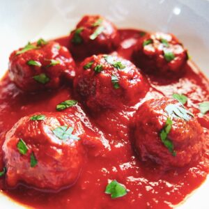 impossible burger meatballs in a white bowl garnished with parsley