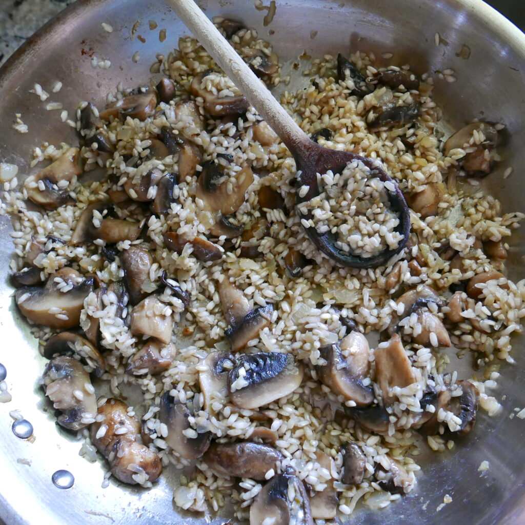 arborio rice and mushrooms in a skillet