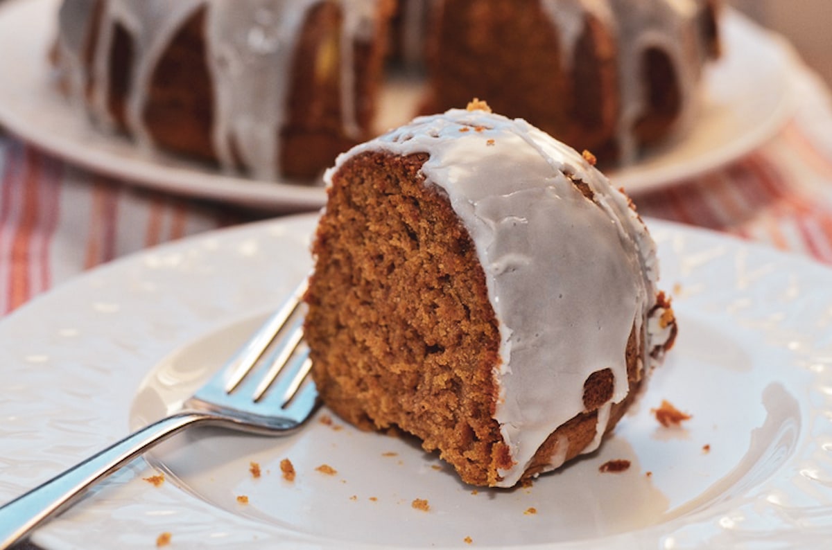 pumpkin spice bundt cake slice on a white plate with fork