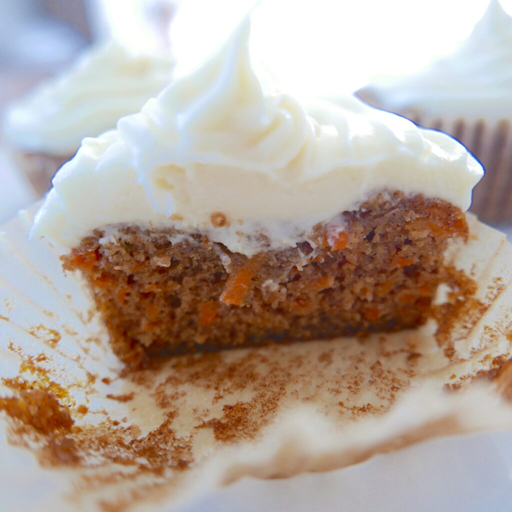 carrot cupcake cut in half on a white plate