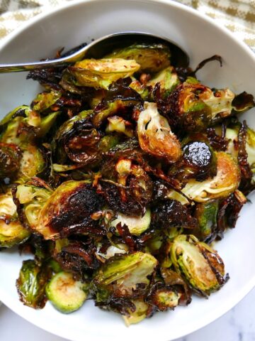 vegan roasted brussel sprouts with garlic in a white bowl