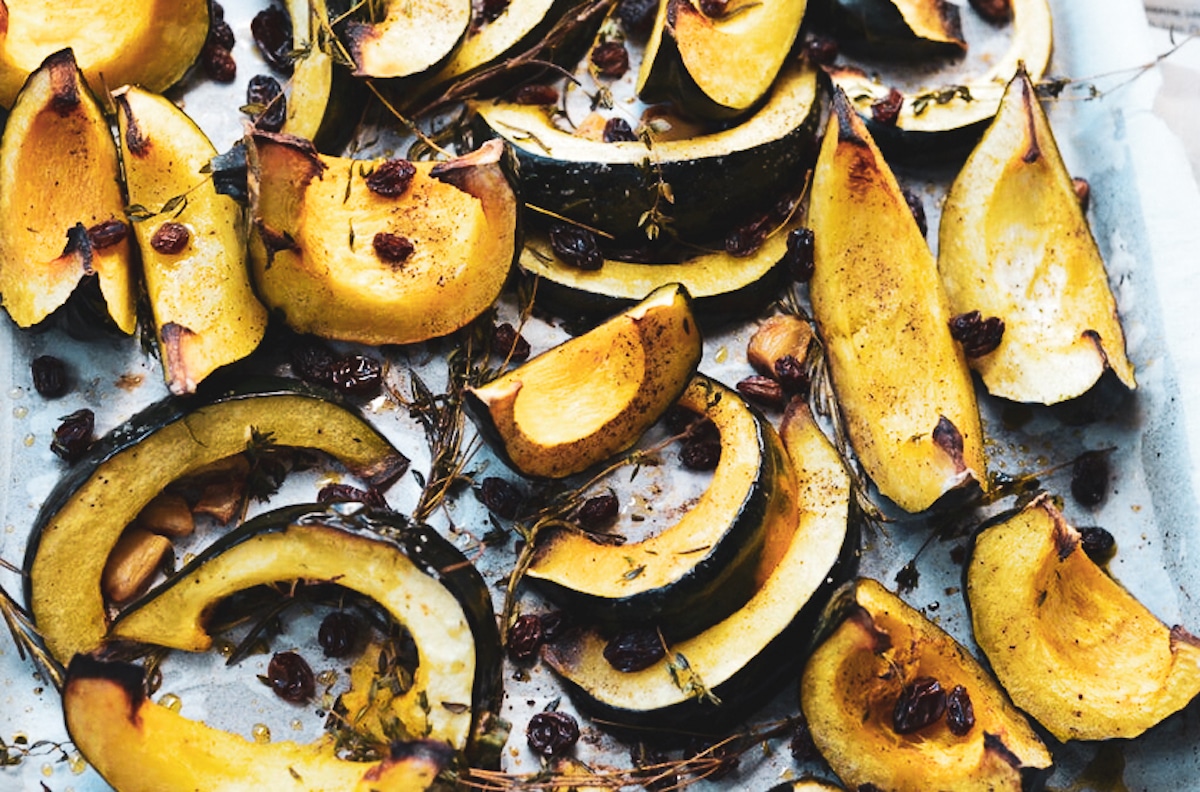 acorn squash wedges with thyme on a baking sheet