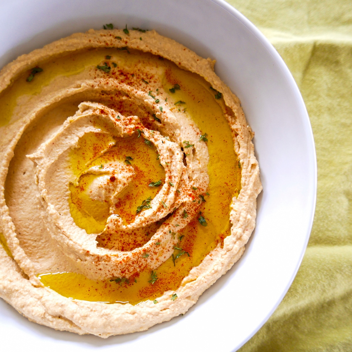 smoked paprika hummus in large bowl on top of a green napkin.