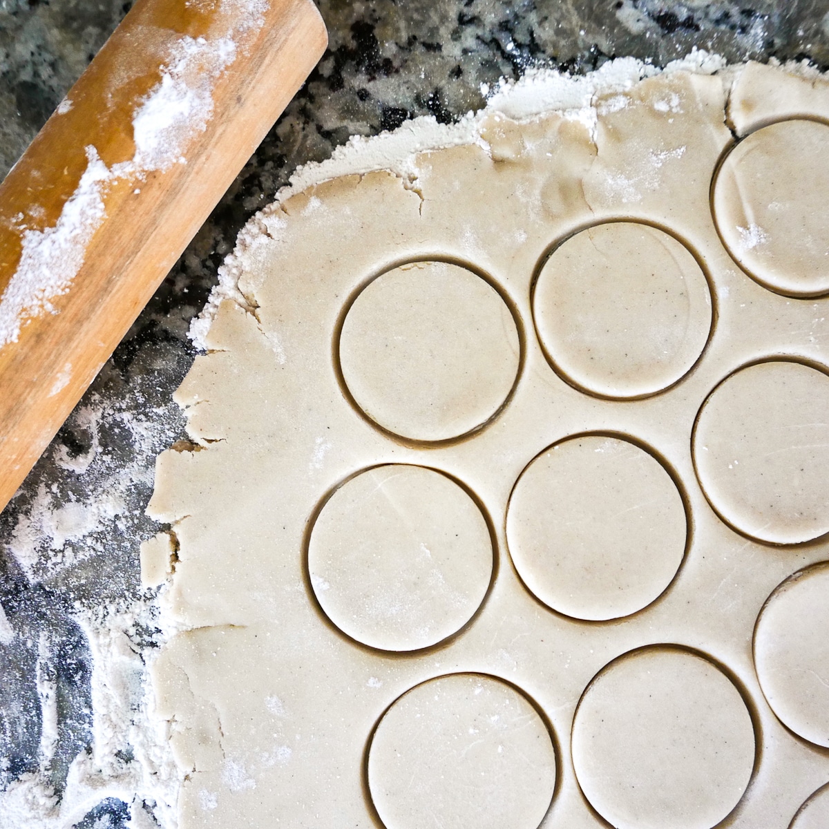 cookie dough being cut out on a work surface.