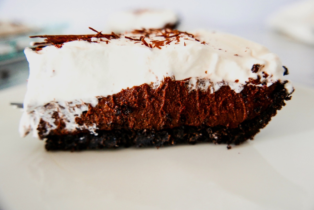 chocolate-cream-pie.jpg side of one slice of chocolate cream pie on a white plate