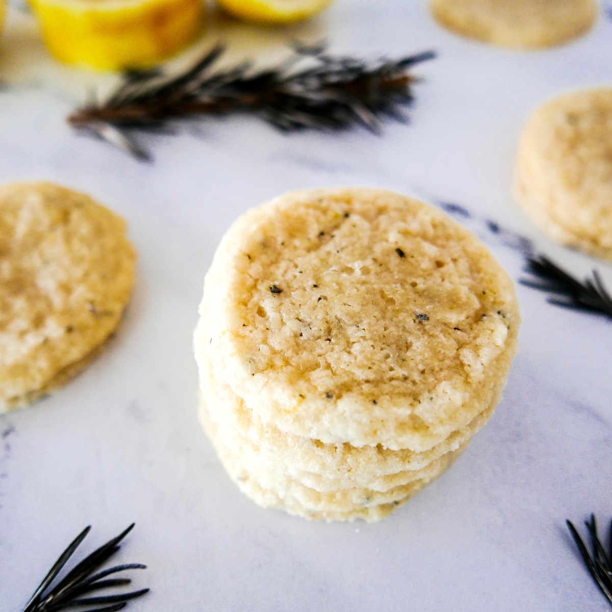 rosemary-lemon-shortbread-cookies.jpg rosemary lemon shortbread cookies stacked with more cookies in background