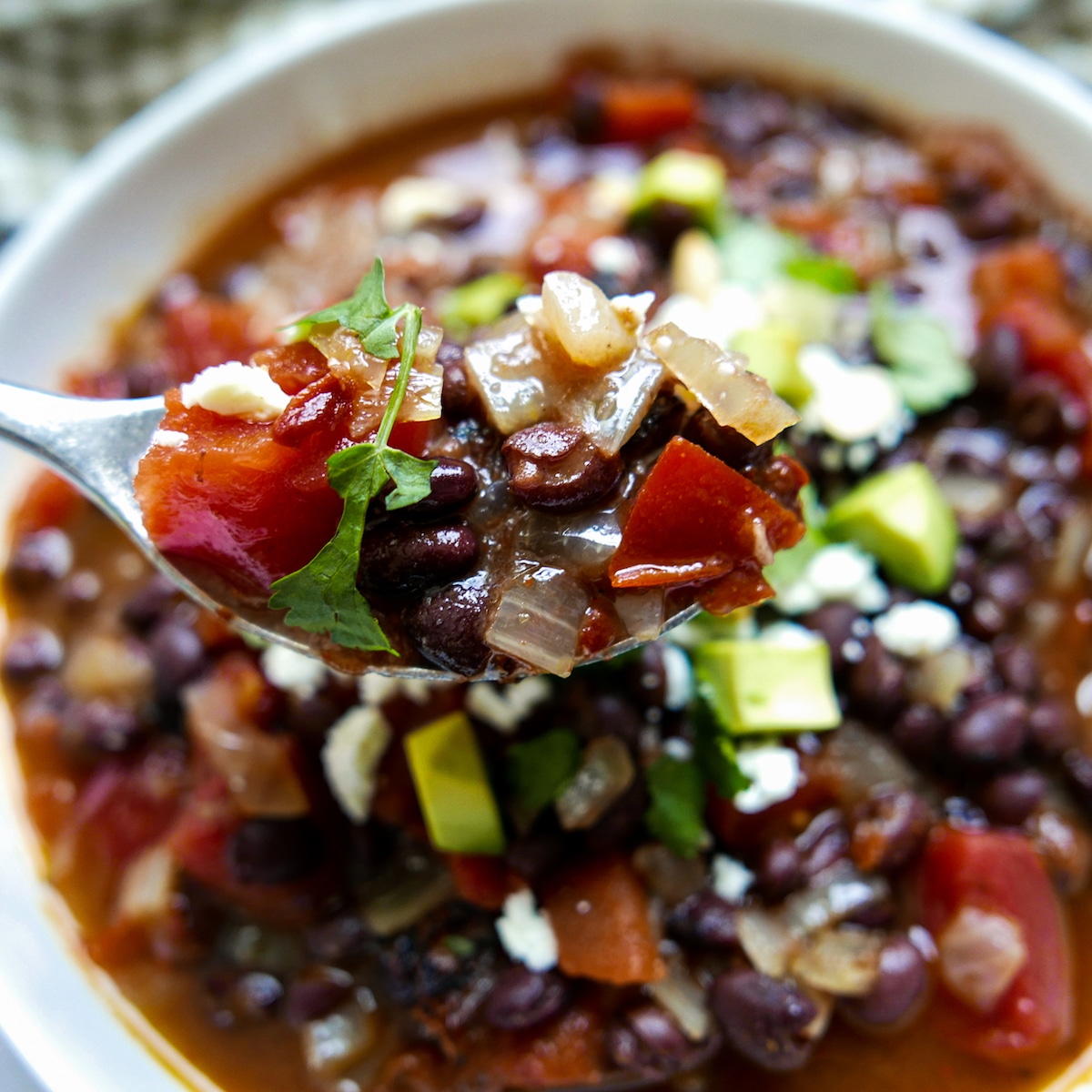 southwest-black-bean-soup-3.jpg southwest black bean soup with spoon lifting up a bite
