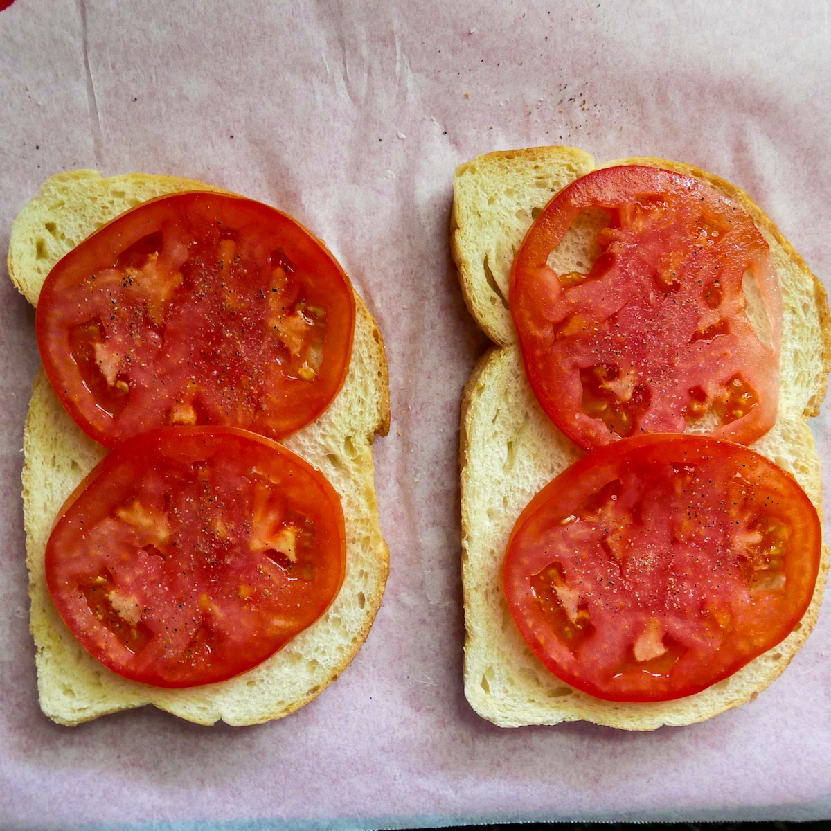 Two tomato slices each on two slices of sourdough bread.