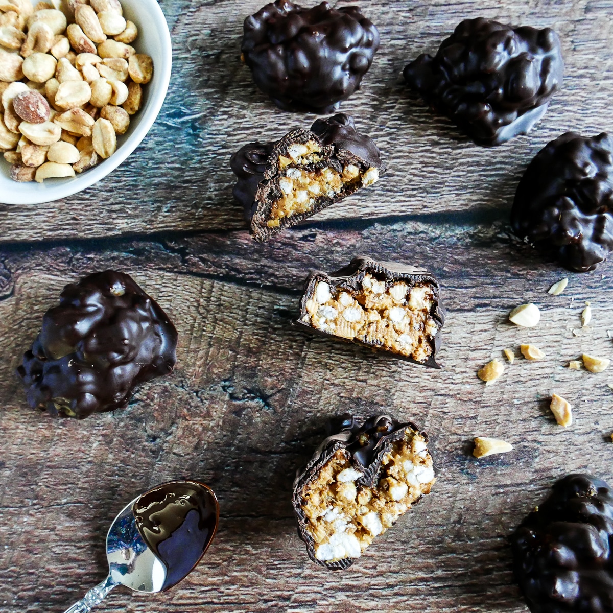 Sliced open peanut butter balls arranged on a wooden table.