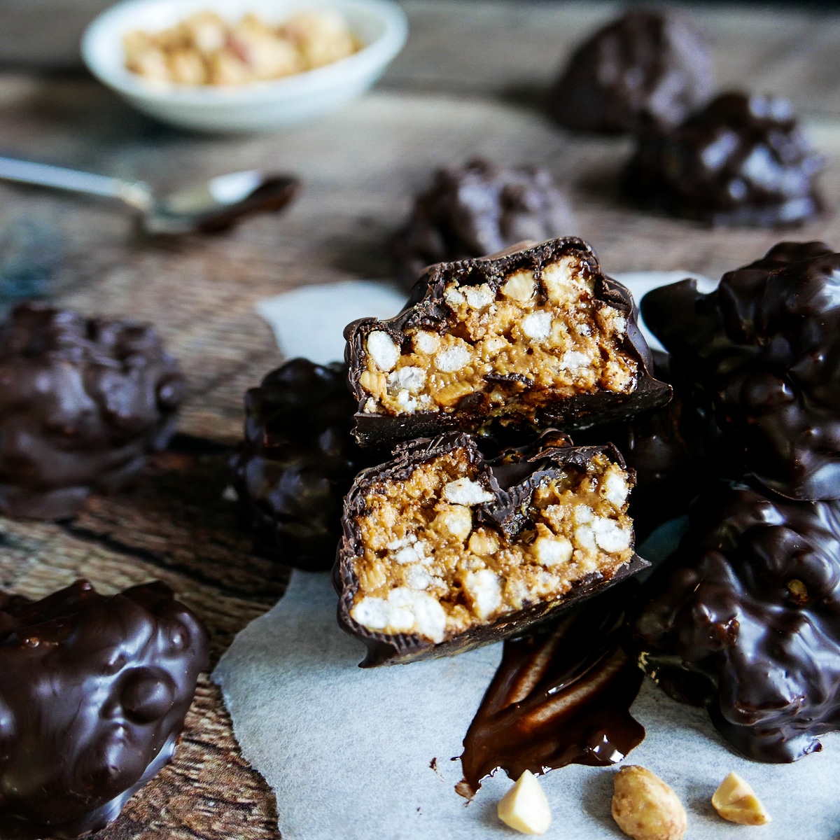 Peanut butter balls with rice krispies arranged on a wooden table.