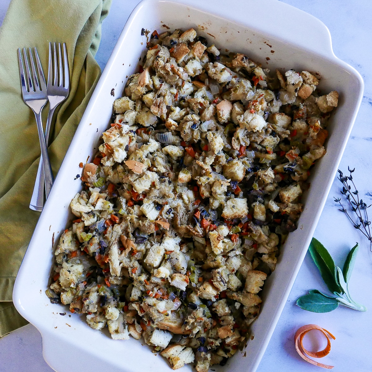 pan of mushroom stuffing with two forks resting on a green napkin.
