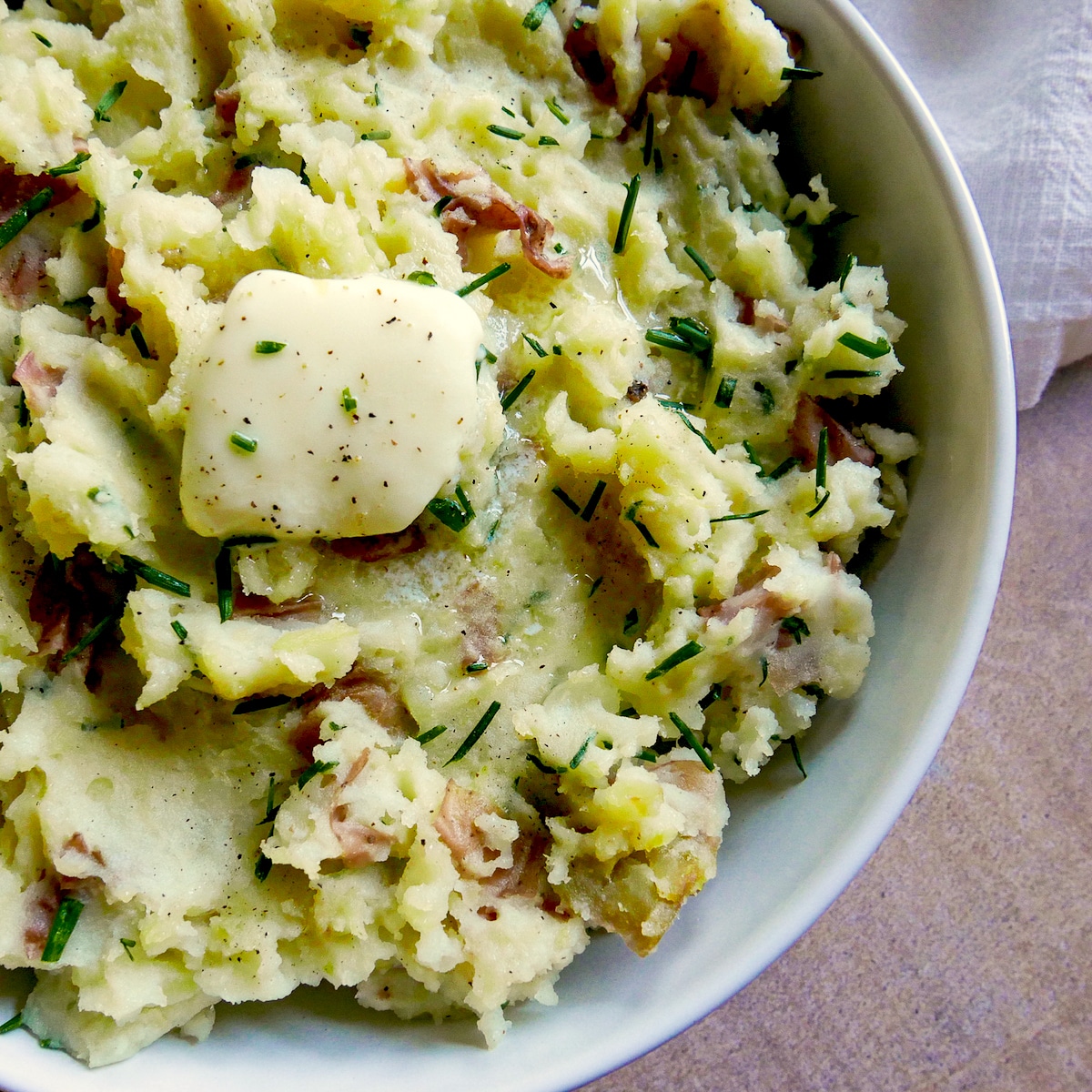 red-skin-mashed-potatoes.jpg red skin mashed potatoes in a bowl with melting butter.