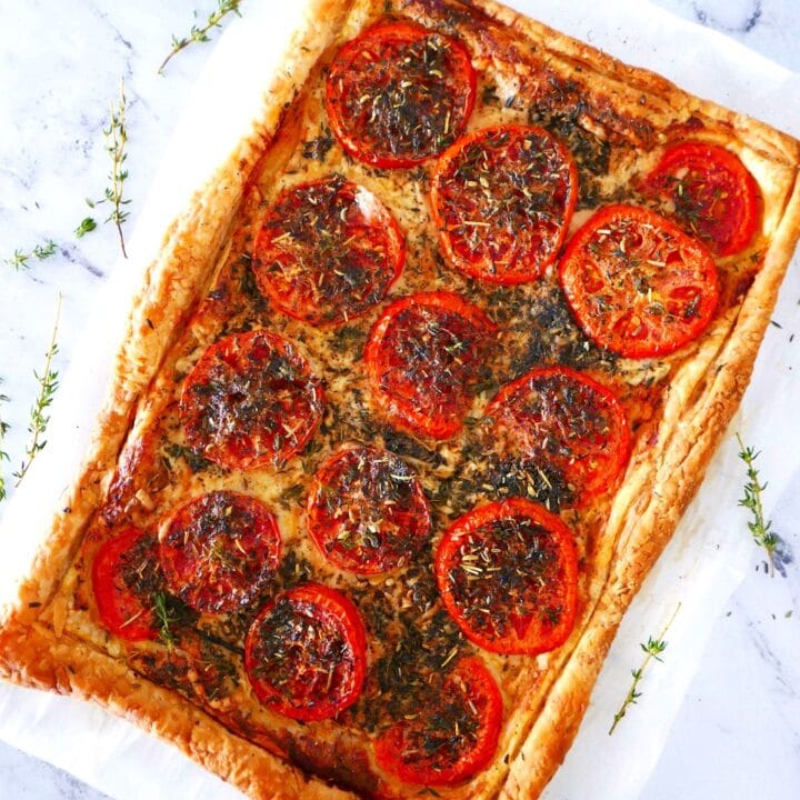 french-tomato-tart.jpg french tomato tart with puff pastry crust arranged on a piece of parchment paper