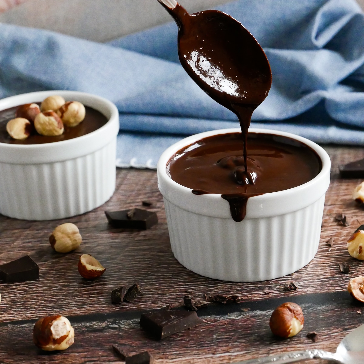 cup of homemade nutella vegan with a spoon dipping into it.