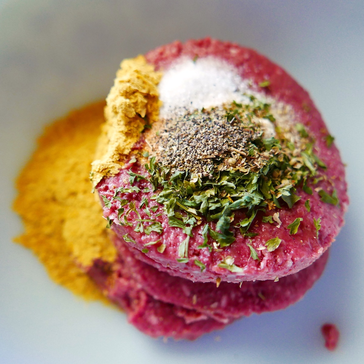 impossible meat in a mixing bowl with spices and nutritional yeast.