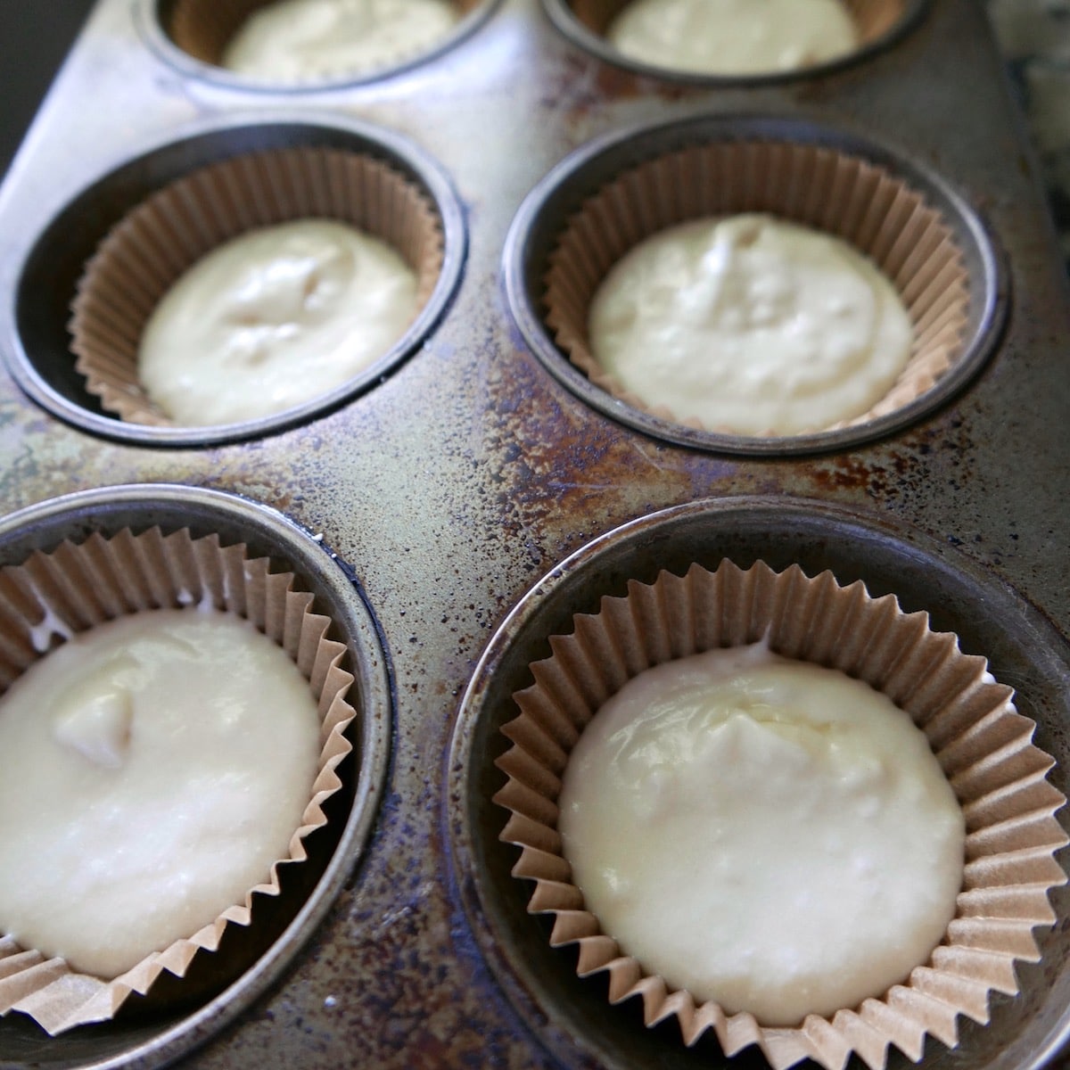 cupcake batter scooped into lined muffin tin.