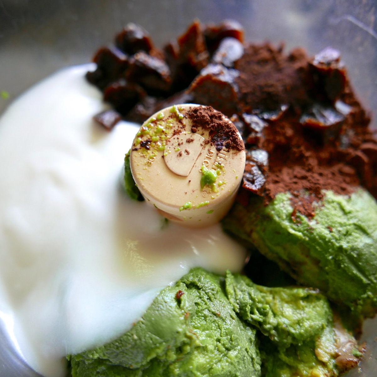 avocado, dates, cocoa powder, and coconut yogurt in a food processor.