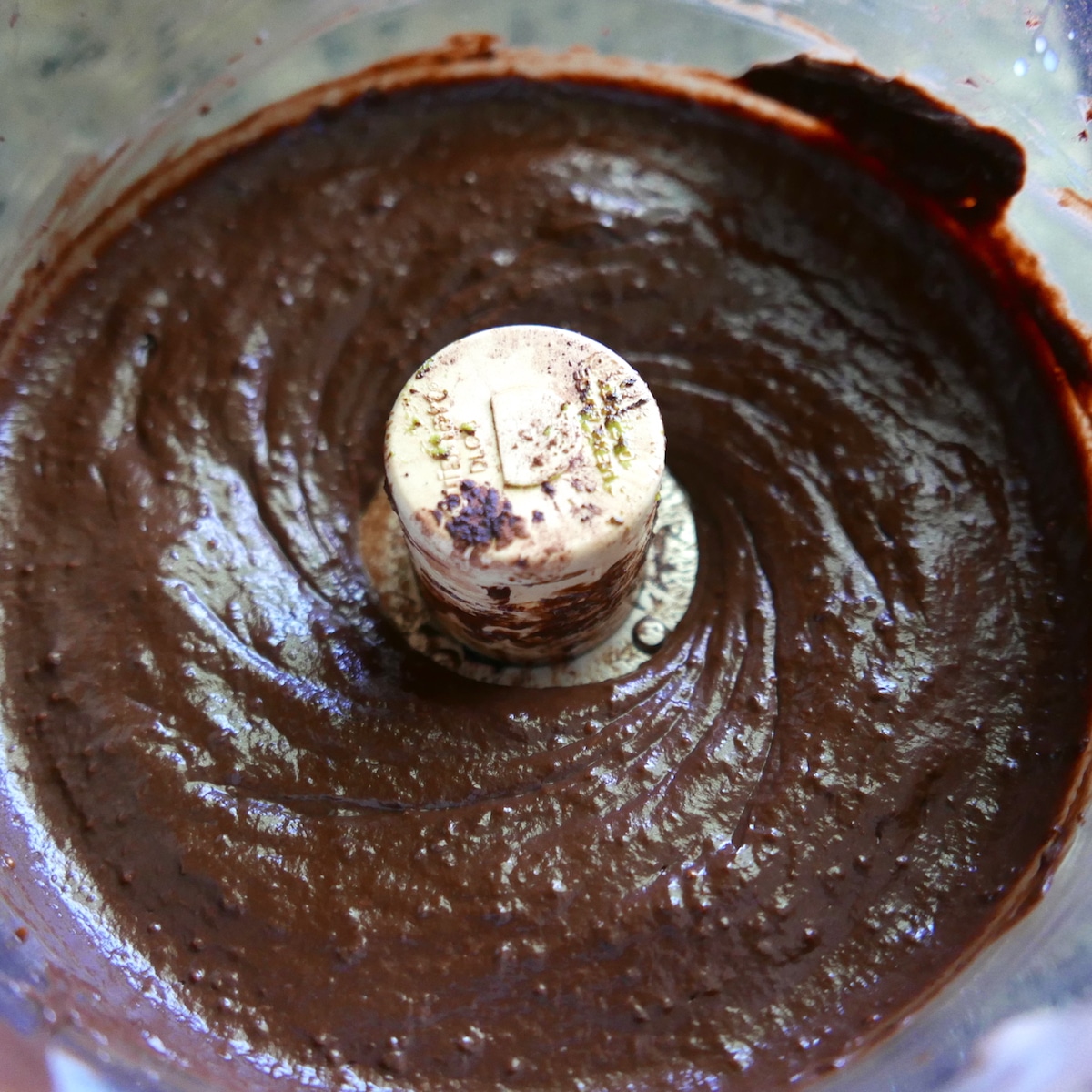 almond milk being mixed into chocolate mousse in a food processor. 