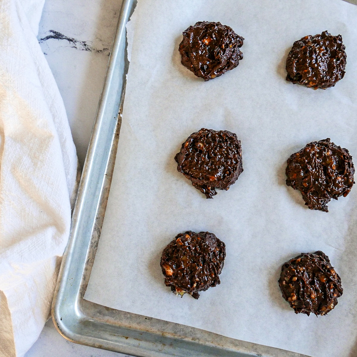Cookie dough scooped onto a baking sheet.