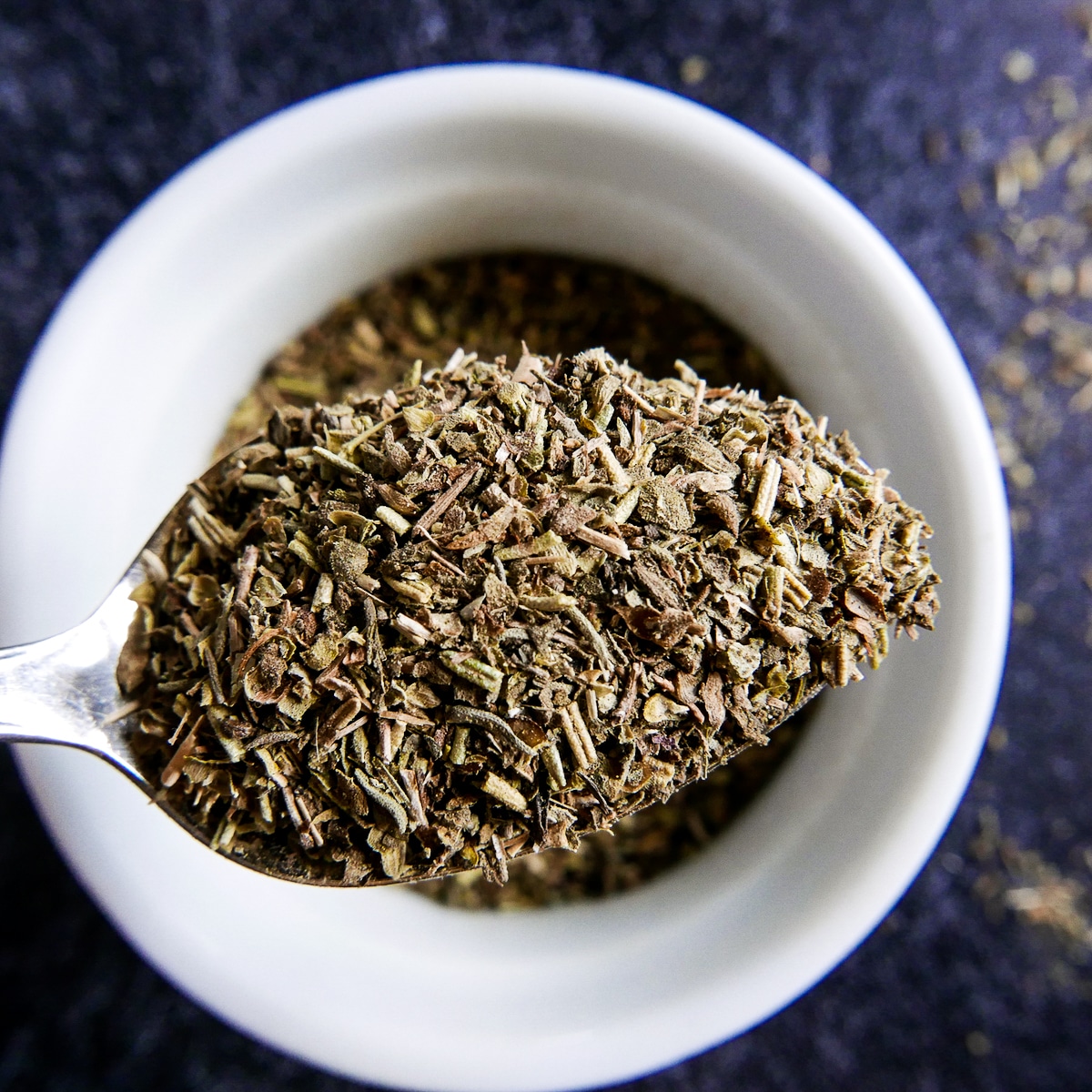 spoon stirring Italian seasoning substitute in a small bowl.