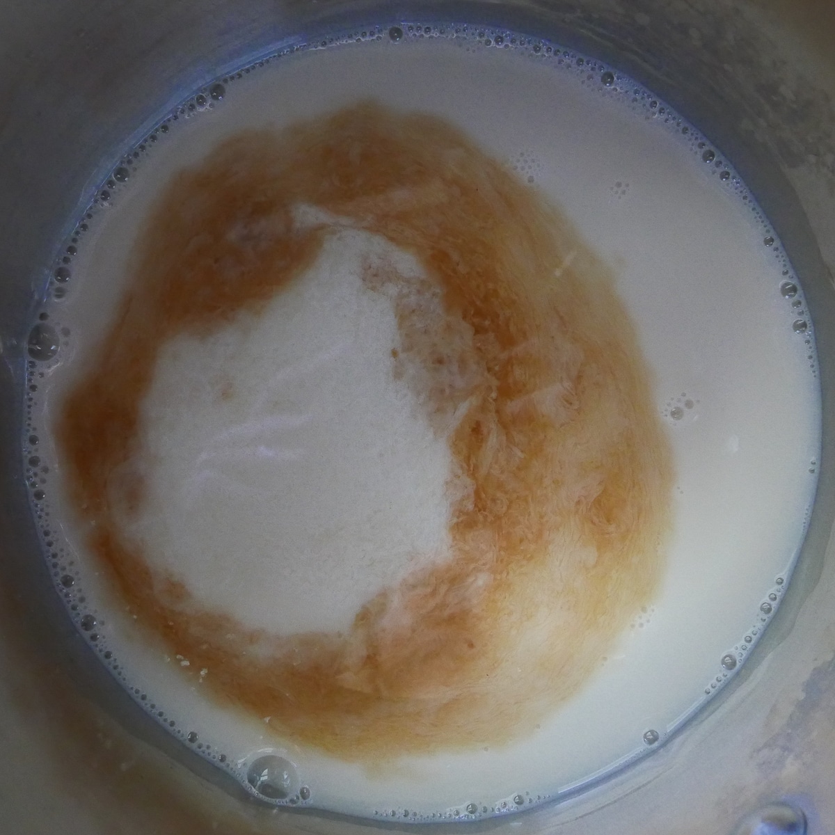 vegan custard being cooked in a sauce pan.